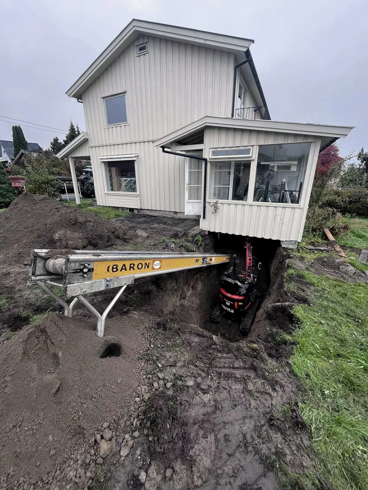 Transportbånd og minigraver under huset
