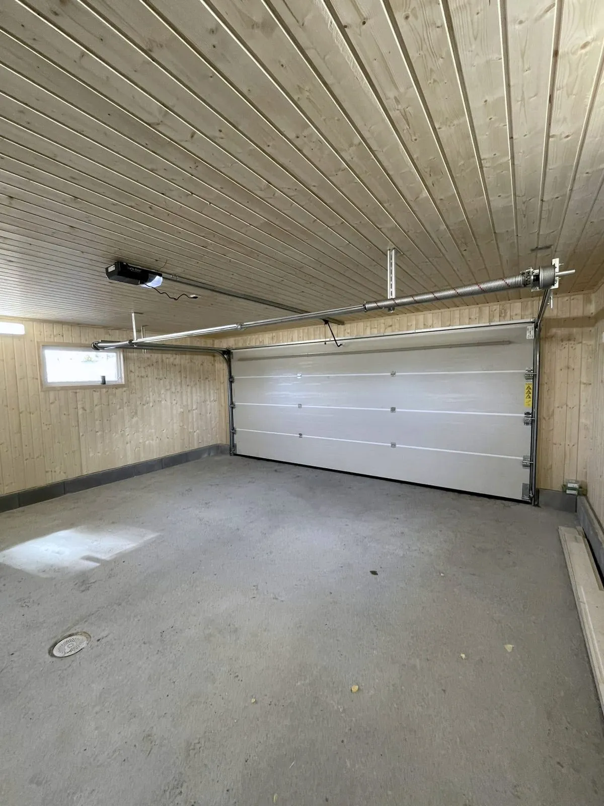 Garasjen innvendig med port og panel i taket